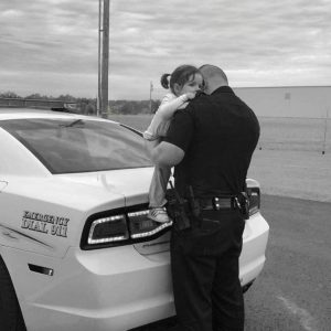 A Tender Moment: A Police Father's Farewell Kiss to His Daughter